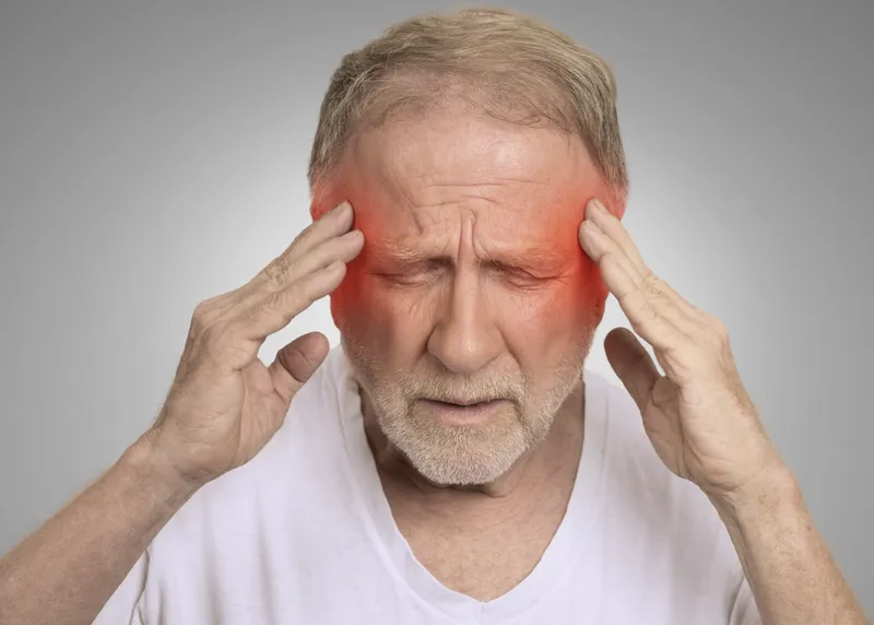 A man presses his fingers to his temples with a stress headache.