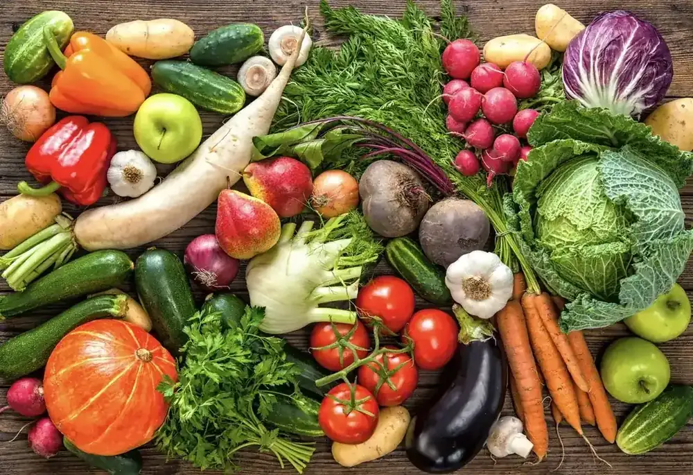 A colourful spread of fresh vegetables and fruit, including beetroot, fennel, radish and squash.